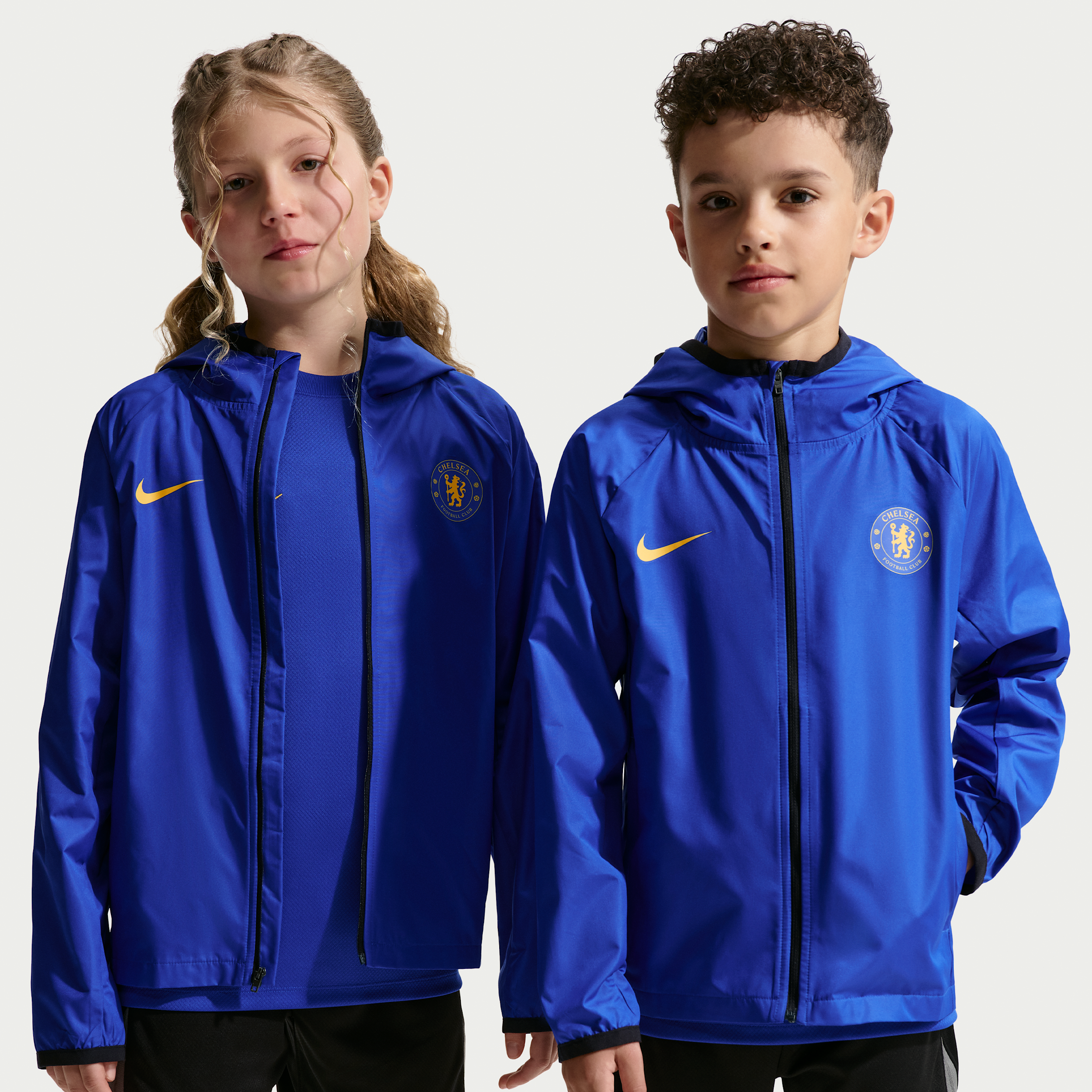 Chelsea FC Academy Pro Nike Storm-FIT-fodboldregnjakke med hætte til større børn - blå