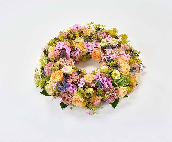 Sommerlig blomsterkrans i pastelfarver, floristens valg.