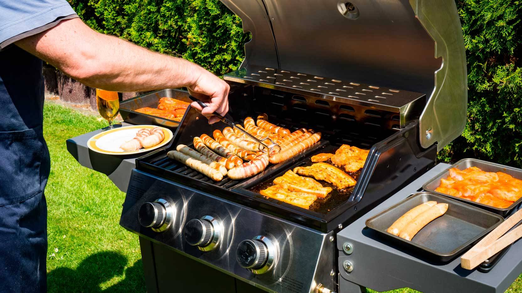 Billede af mand, der vender maden på grillen med en grilltang