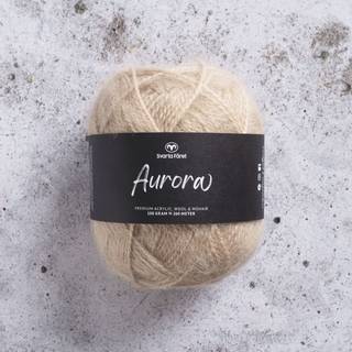 Svarta Fåret Aurora 31608 shimmering beige Indhold: 70 % premium akryl, 15 % mohair, 15 % uld Vægt/længde: 100 g = ca. 260 meter Anbefalede pinde: 6 mm Strikkefasthed: 10 cm = 14 masker Vaskes på skåneprogram maks. 30°C / Tørres fladt.
