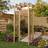 Rowlinson 134cm W x 72cm D Solid + Manufactured Wood Arbour in Natural