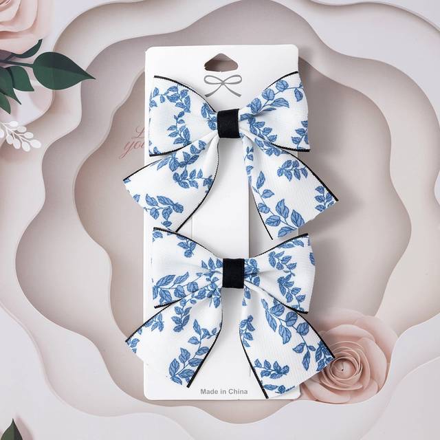 SHEIN 2pcs Toddler Girls Floral Print Bow Decor Hair Clip