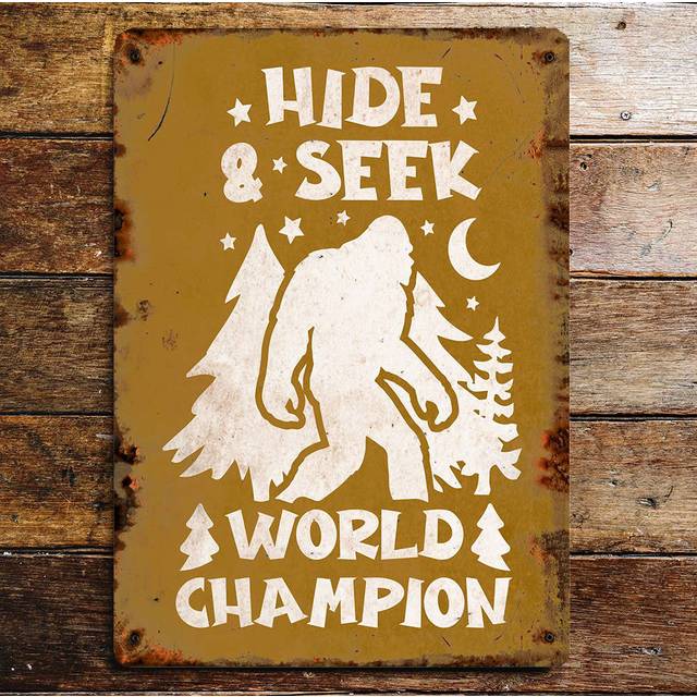 Bigfoot Hide And Seek World Champion Metal Wall Sign Plaque - Brown;White (20cm H X 15cm W)
