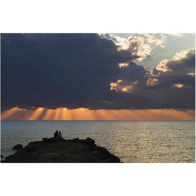Dramatic Sky with Orange Sun Rays Reaching Down To The Water on The Horizon Out of Storm Clouds Poster Print - 38 x 24 in. - Large