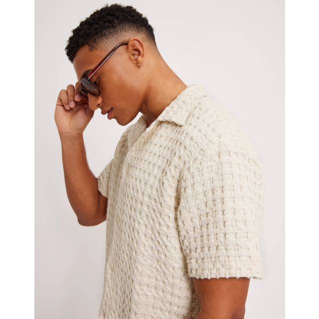 Waffle-Textured Cuban Shirt - Ecru - OAS, founded by Oliver Adam Sebastian, is a resort brand specialising in year-round vacation wear. Born from a reaction to Swedish winters after many trips to the family summer home in Barcelona, the label draws inspiration from art, architecture and culture, and features everything from bright and bold swimwear to quirky footwear, for all your holiday needs.